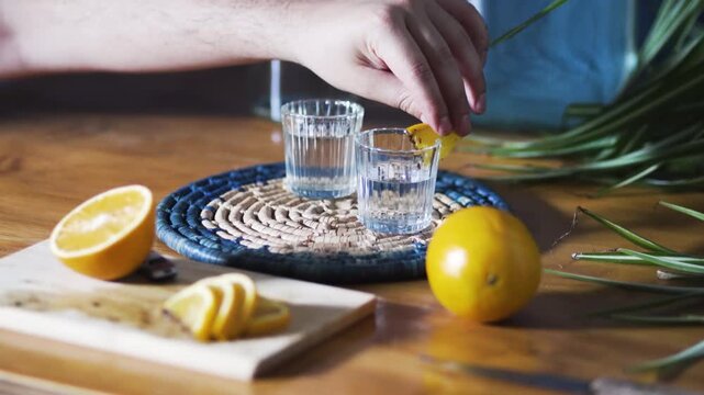 Person garnishing and grabbing two mezcal or tequila shots