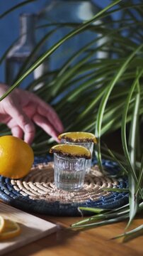 Hand taking mezcal or tequila shot with orange and sal de gusano.