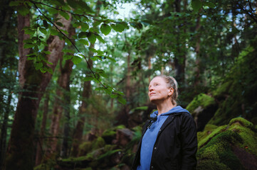 Naklejka premium Serene 50s female traveler enjoying nature mindfulness and tranquility in the woods