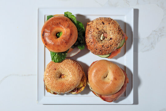 Top View Assortment of Fresh Bagel Sandwiches on White Background