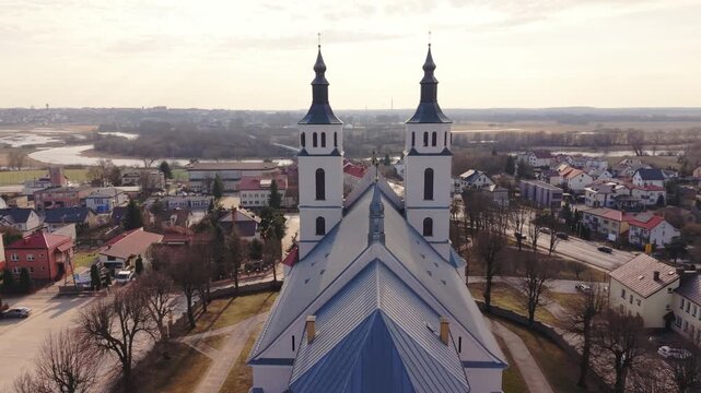 Aerial Architectural Study Of Twin Towers Piatnica Focusing On Symmetry And Rooflines, Late Afternoon Glow, Village Context, Panoramic Composition Ideal For Design, Heritage And Documentary
