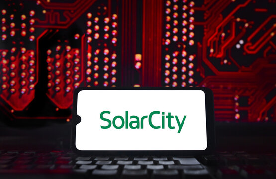 SolarCity logo on a smartphone screen with a red, technological background.
