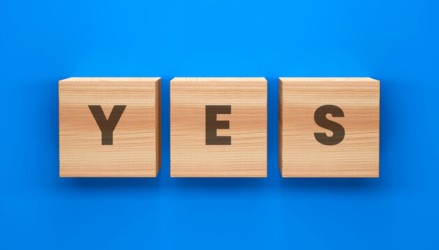 Three Wooden Cubes Spelling YES on a Blue Background