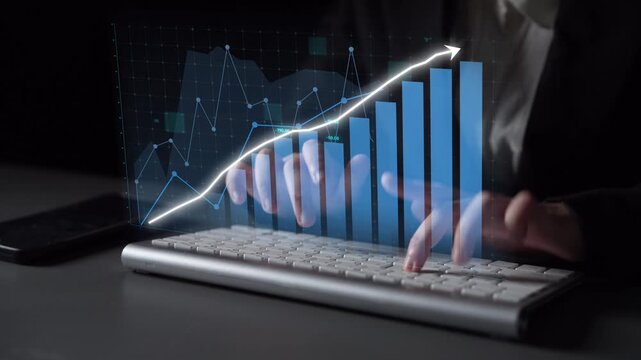 A business professional types on a keyboard, analyzing financial data displayed through digital charts and graphs on a dark background, representing modern finance. Copula