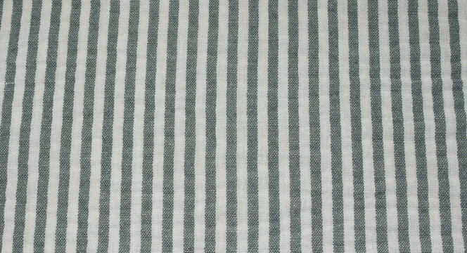 Close up of wrinkled grey and white vertical striped fabric. Texture of crumpled classic grey striped polyester cloth background.	