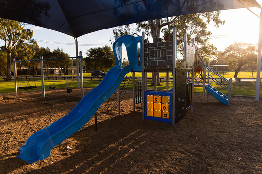 slide and play fort at a small playground in afternoon light