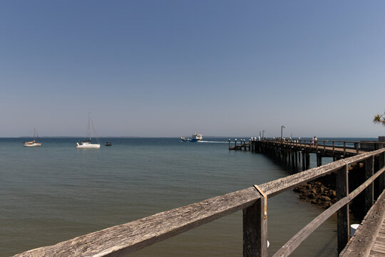 wooden jetty on a sunny day with boats in the water