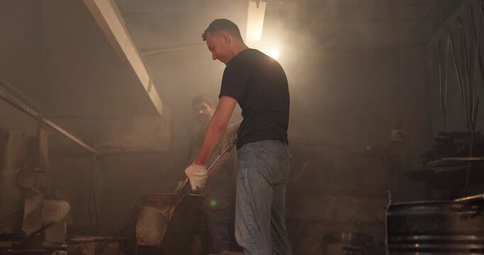 Foundry Workers Pouring Molten Metal in Traditional Casting Workshop