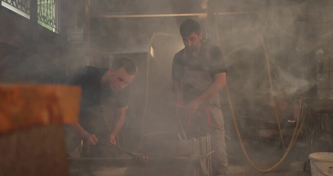 Foundry Workers Pouring Molten Metal in Traditional Casting Workshop