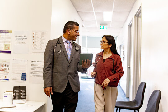 Doctors walking and conversing in clinic hallway