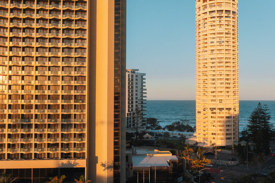 Golden hour illuminates coastal high-rise buildings overlooking the ocean