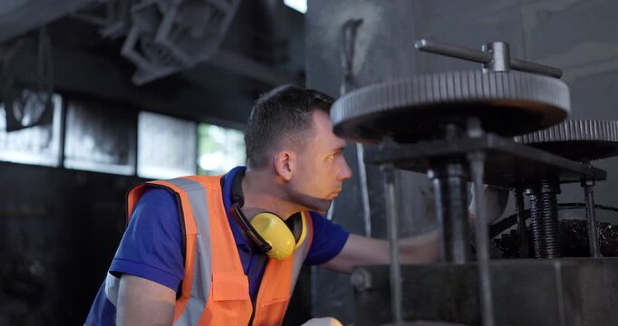  Technician Adjusting Heavy Industrial Machine in Traditional Metal Workshop
