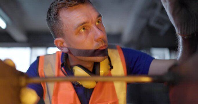 Technician Adjusting Heavy Industrial Machine in Traditional Metal Workshop