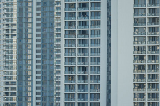 Modern residential towers with balconies and glass windows reflecting the sky