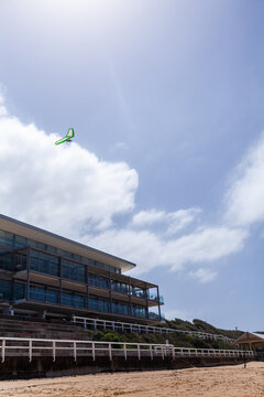 Hang glider in sky above coastal multi-storey building overlooking Merewether beach