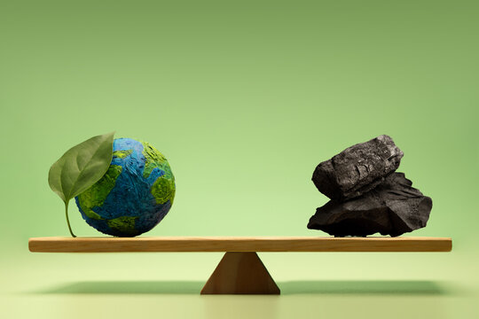 arth globe with leaf balanced against coal ,Climate responsibility, carbon emission impact