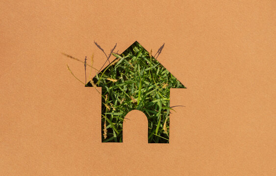 House symbol with grass texture cut on paper,sustainable housing, green living