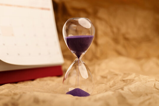 Hourglass beside calendar, time management, aging society and awareness
