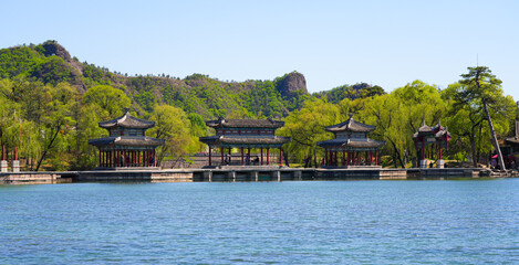 Obraz premium Traditional wooden pavilions and stone bridges with water reflections at the scenic lake area of Chengde Mountain Resort, Hebei, China