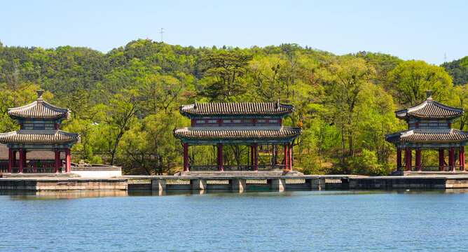 Traditional wooden pavilions and stone bridges with water reflections at the scenic lake area of Chengde Mountain Resort, Hebei, China