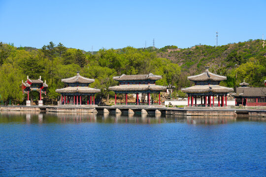 Traditional wooden pavilions and stone bridges with water reflections at the scenic lake area of Chengde Mountain Resort, Hebei, China