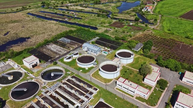 Aerial wastewater treatment plant circular clarifiers overhead drone perspective showing round clarifier tanks aeration basins sludge ponds service buildings