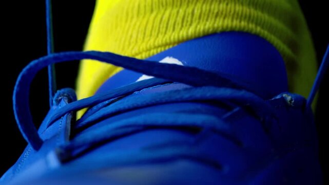 Football Boots: Unrecognizable Soccer Player Tying Shoelaces on Leather Football Cleats Close up in Slow motion 4K Ultra HD footage.

