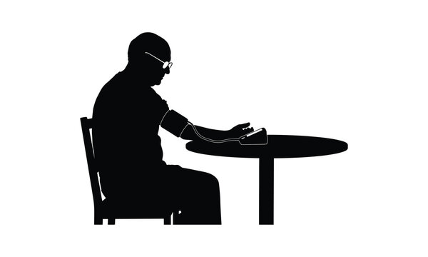 Silhouette of an elderly man checking his blood pressure at a table in a medical environment
