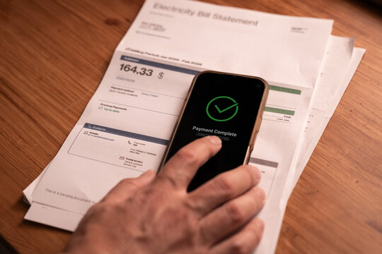 Successful bill payment on smartphone with utility invoice on table at home