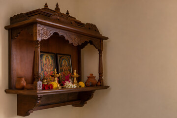 Obraz premium Warm wooden mandir altar with diyas and flowers