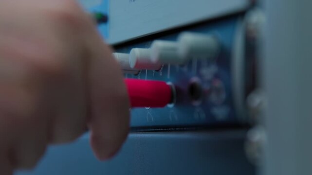 Connecting a red plug to the soundbar on a desk