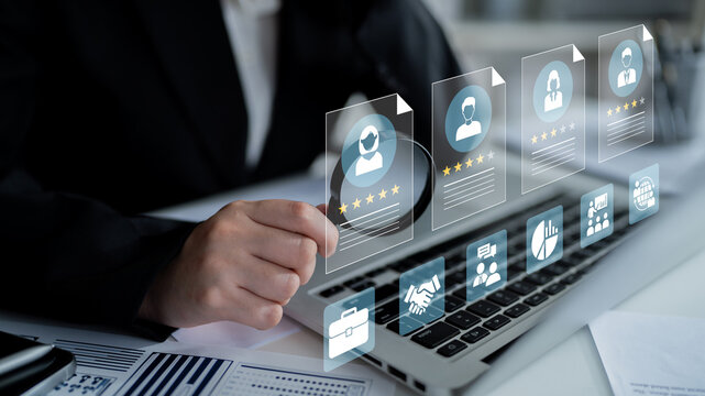 A business professional is assessing performance metrics and user profiles on a laptop, surrounded by digital elements in a modern office environment. Ledger