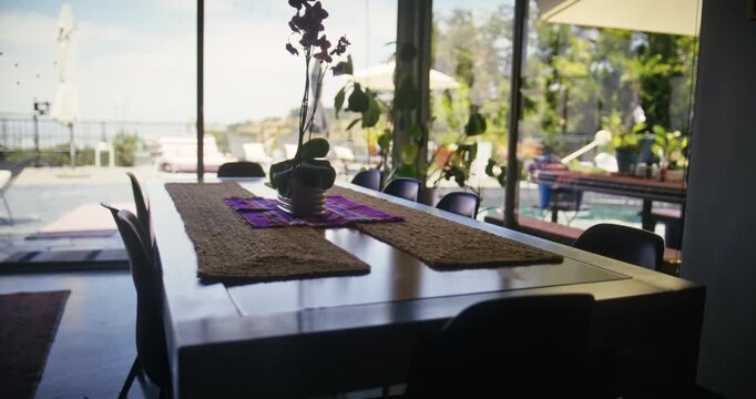 Slow, steady cam silhouette of beautiful table set up inside luxury home with plant