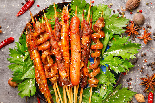 Grilled Meat and Vegetable Kebabs on Wooden Skewers with Fresh Herbs and Spices