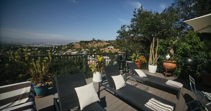 Luxury home deck looking over California desert hills and valley - wide, steady cam shot