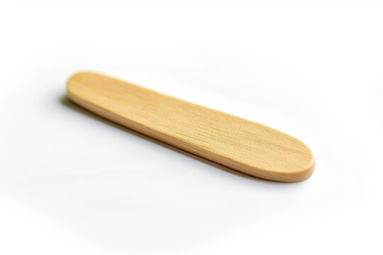 A simple wooden popsicle stick rests on a clean white surface, highlighting its natural material and smooth finish.