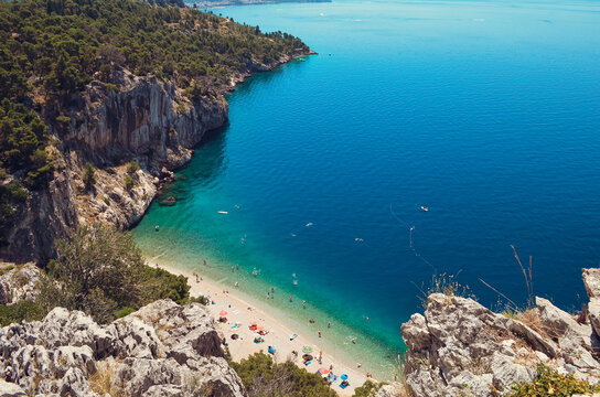 Hidden FKK beach surrounded by dramatic cliffs and turquoise Adriatic water on the Makarska Riviera in Croatia. A scenic Mediterranean escape perfect for summer travel campaigns, slow tourism concepts