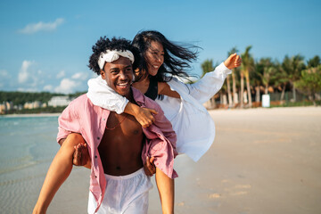 Happy interracial couple embracing and laughing at a scenic tropical beach resort on summer vacation © NDABCREATIVITY