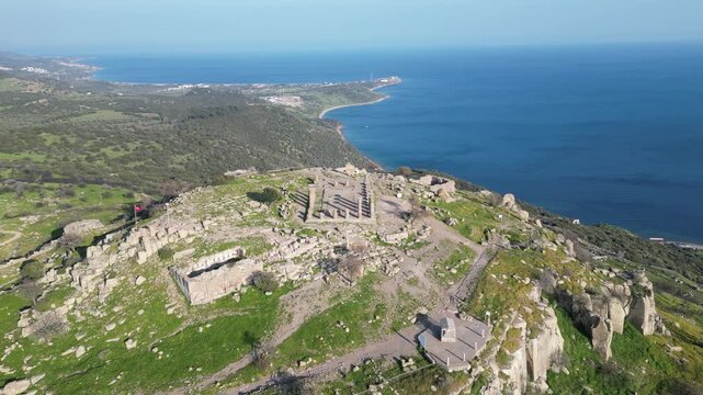 Aerial view of the ancient Temple of Athena ruins on the acropolis of Assos (Behramkale) over the Aegean Sea in Canakkale, Turkey. 4K resolution stock footage. High quality 4k footage