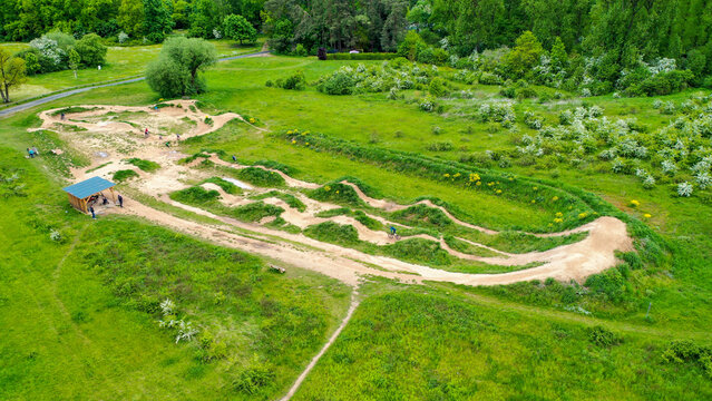 Forchheim, Germany - 16 May 2026: Aerial view of Monkey Island Dirt Park with its undulating dirt tracks, jumps, and lush green vegetation.