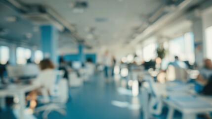 Fototapeta premium Blurred view of busy modern office space with employees working at desks under bright natural light.