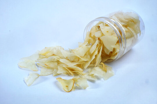 cassava chips or keripik singkong traditional chips from indonesia in an open plastic container, ready to be enjoyed while relaxing, isolated on white background