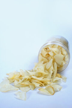 cassava chips or keripik singkong traditional chips from indonesia in an open plastic container, ready to be enjoyed while relaxing, isolated on white background