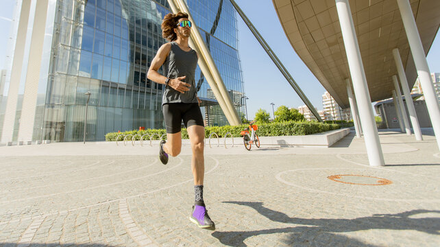 Runner enjoys a sunny workout near modern architecture in an urban space