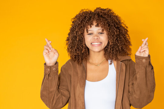 isolated young woman with a wishful and lucky expression