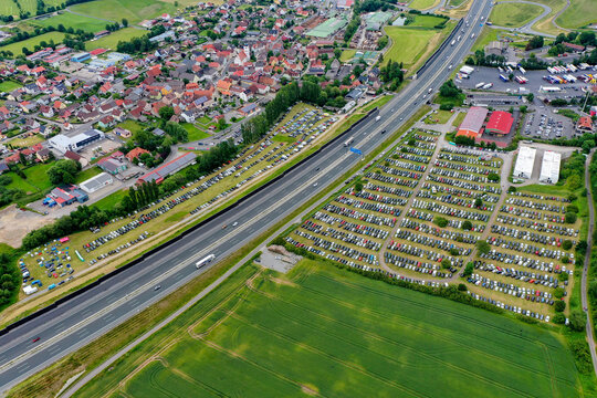 Geiselwind, Germany - 20 June 2025: Aerial view of Heroes Festival Geiselwind featuring massive parking lots filled with cars next to the A3 motorway and the town rooftops.