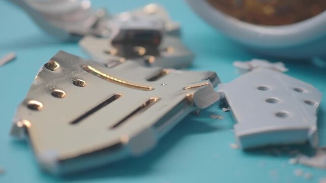 Broken pieces of a toy on a blue surface