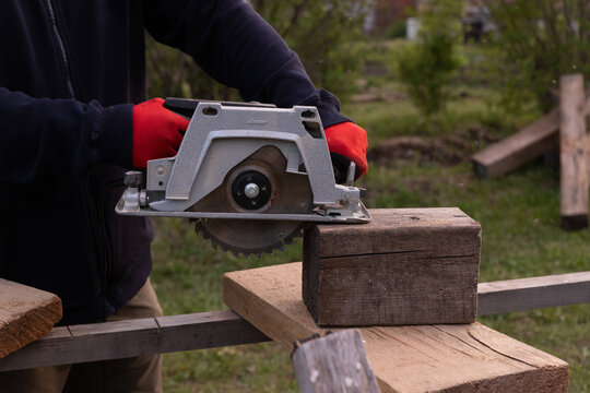 Electric circular saw with blade cutting board during DIY repair