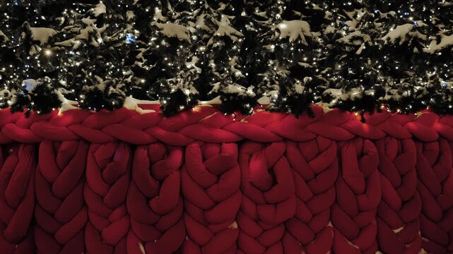 Christmas tree base with deep red chunky knit blanket and shining holiday lights