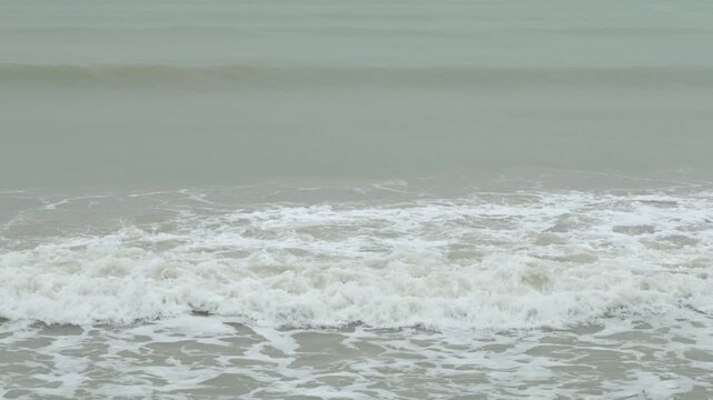 landscape view of heavy wave oceanic foam is coming to the beach while in storming heavy raining weather. aerial footage landscape and water waves with nobody. vacation outdoor landscape texture